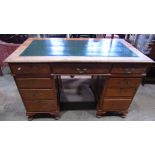 An early 20th century oak kneehole twin pedestal writing desk with inset writing surface over an
