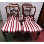 A set of four mid Victorian rosewood dining chairs with carved and pierced splats, upholstered seats