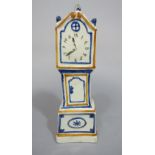 An early 19th century cream glazed model of a miniature longcase clock with painted detail in the