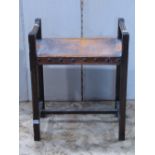 An arts and crafts style stained oak stool, with chamfered frame and worn leather seat, with studded