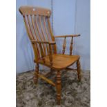 A Windsor elm and beechwood lathe back armchair, raised on turned supports united by a further