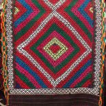 A colourful Kelim runner with geometric medallion pattern upon a dark ground, 300 x 70cm