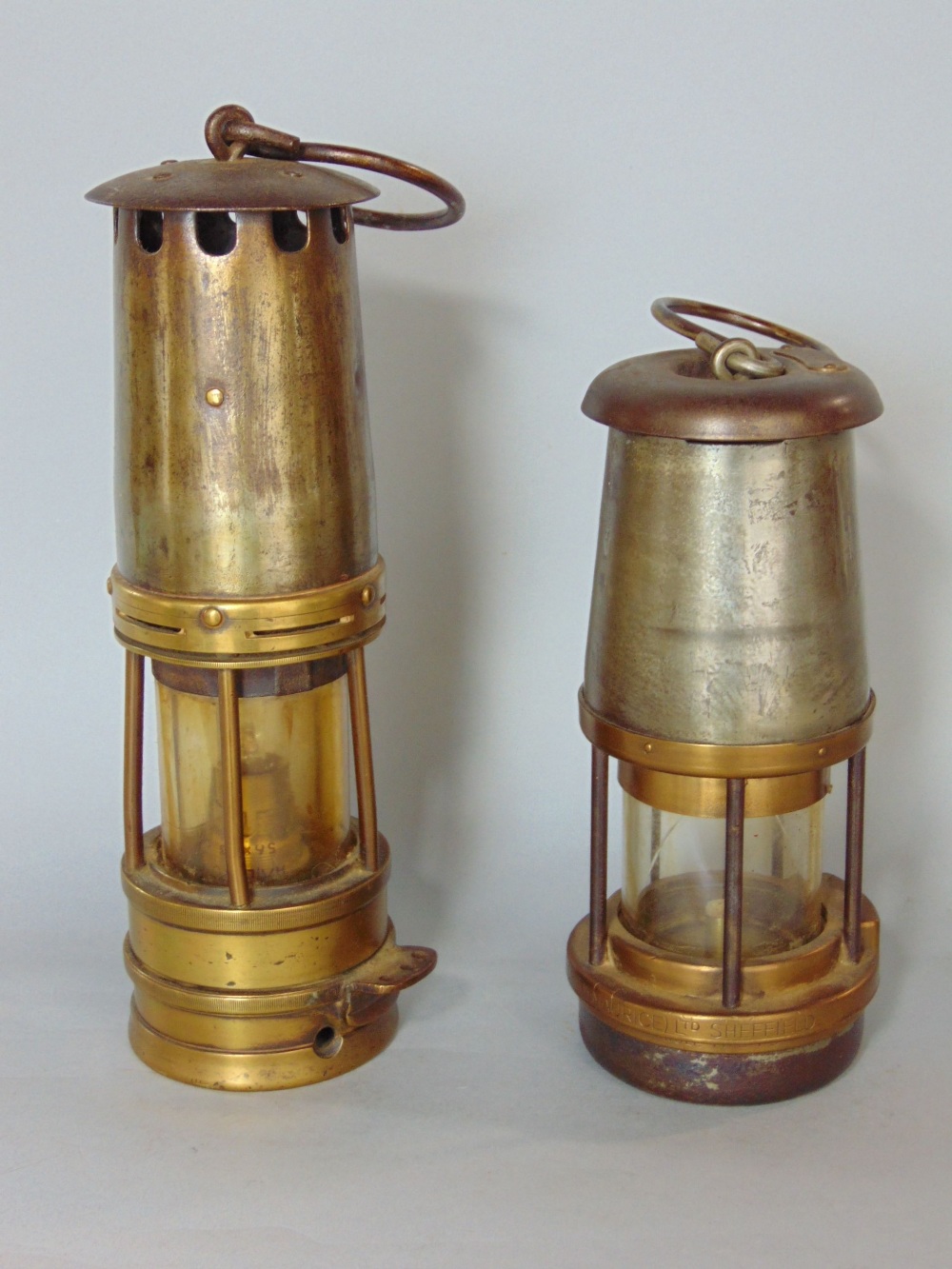 Two antique steel and brass miners lamps, the largest by The Wolf Safety Lamp Co, Sheffield, the