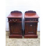 A pair of reproduction hardwood bedside cupboards each enclosed by a fielded arched panelled door