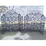 A pair of good quality iron work folding fire guards with decorative scrollwork detail and wire mesh