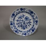 A 19th century Meissen type charger with blue and white painted floral decoration with blue cross