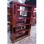 A hardwood floorstanding open shelving unit, partially enclosed and fitted with small drawers and
