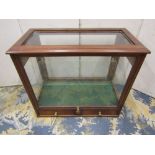 A small table top display cabinet with glazed sides and top, rising front over two frieze drawers,