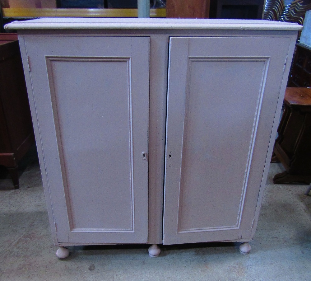 A low freestanding painted side cupboard enclosed by a pair of rectangular moulded panelled doors