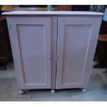 A low freestanding painted side cupboard enclosed by a pair of rectangular moulded panelled doors