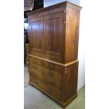 A Georgian stripped and waxed pine livery cupboard, the upper section enclosed by a pair of