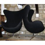 A pair of retro swivel egg shaped moulded fibre glass chairs with upholstered finish raised on