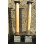 A pair of large architectural wooden cylindrical columns with all over later simulated marble hand