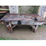 A vintage rustic pine workshop bench, with thick planked top and original wooden screw vice,