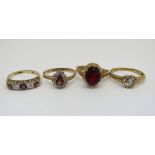 Four 9ct paste set dress rings to include a pink stone and cubic zirconia half hoop example, sizes K