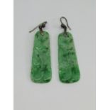 Pair of carved jade drop earrings with pierced detail and silver hooks