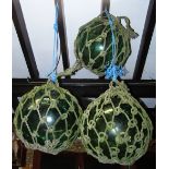 Three large vintage green tinted hand blown rope twist encased fishing floats 18 inches in