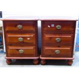 A pair of modern pine three drawer bedside chests with brass ring handles and turned supports