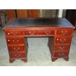 A reproduction Georgian style kneehole twin pedestal, mahogany veneered writing desk with green