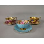 An Aynsley cabinet cup and saucer with painted fruit decoration to the exterior and gilt interior