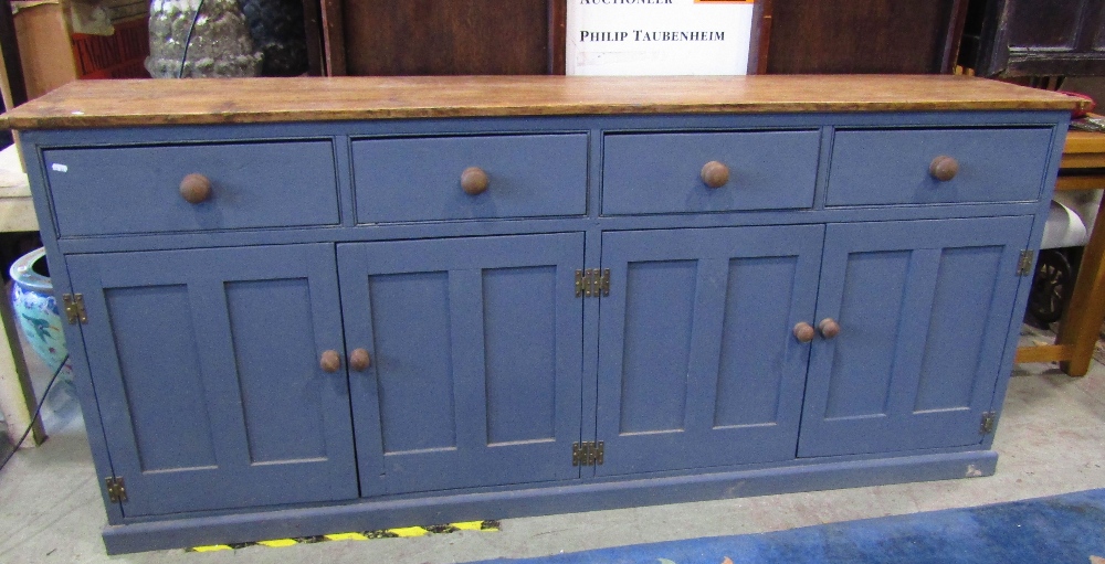 A rustic reclaimed pine kitchen dresser base, enclosed by four rectangular twin panelled doors,