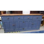 A rustic reclaimed pine kitchen dresser base, enclosed by four rectangular twin panelled doors,