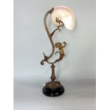 French cast metal figural table lamp decorated with a putti, with conche shell shade