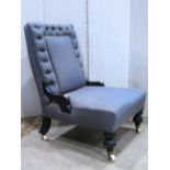 A late Victorian nursing chair with repeating floral sprig patterned upholstery on a blue ground,