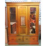A late Victorian/Edwardian walnut triple wardrobe with moulded cornice over three, three quarter