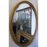 An Edwardian gilt framed wall mirror of oval form, with bevelled edge plate and moulded surround,