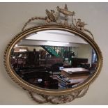 A Georgian style oval gilt framed wall mirror with bevelled edge plate and moulded outline, with