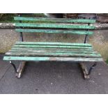 A two seat garden bench with green painted timber lathes, raised on sprung steel supports, 4ft long
