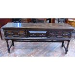 A Jacobean style oak dresser/side table enclosed by three frieze drawers with applied geometric