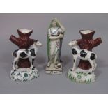 A pair of 19th century pottery spill holders in the form of tree trunks with applied figures of