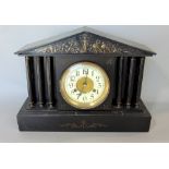 A 19th century black slate architectural mantle clock, the twelve inch dial with enamel chapter