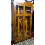 A 1930s oak side cabinet, freestanding and enclosed by a pair of full length rectangular glazed