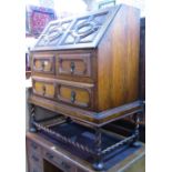 A 1920s Jacobean revival oak writing bureau, with geometric block moulded detail, the fall flap