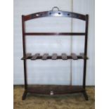 A 19th century mahogany freestanding boot rack to hold six pairs beneath an arched rail with