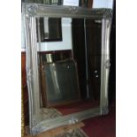 A large contemporary reproduction wall mirror of rectangular form with bevelled edge plate, set