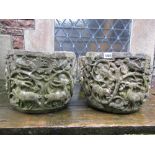 A pair of weathered cast composition stone garden planters of squat circular form, with raised