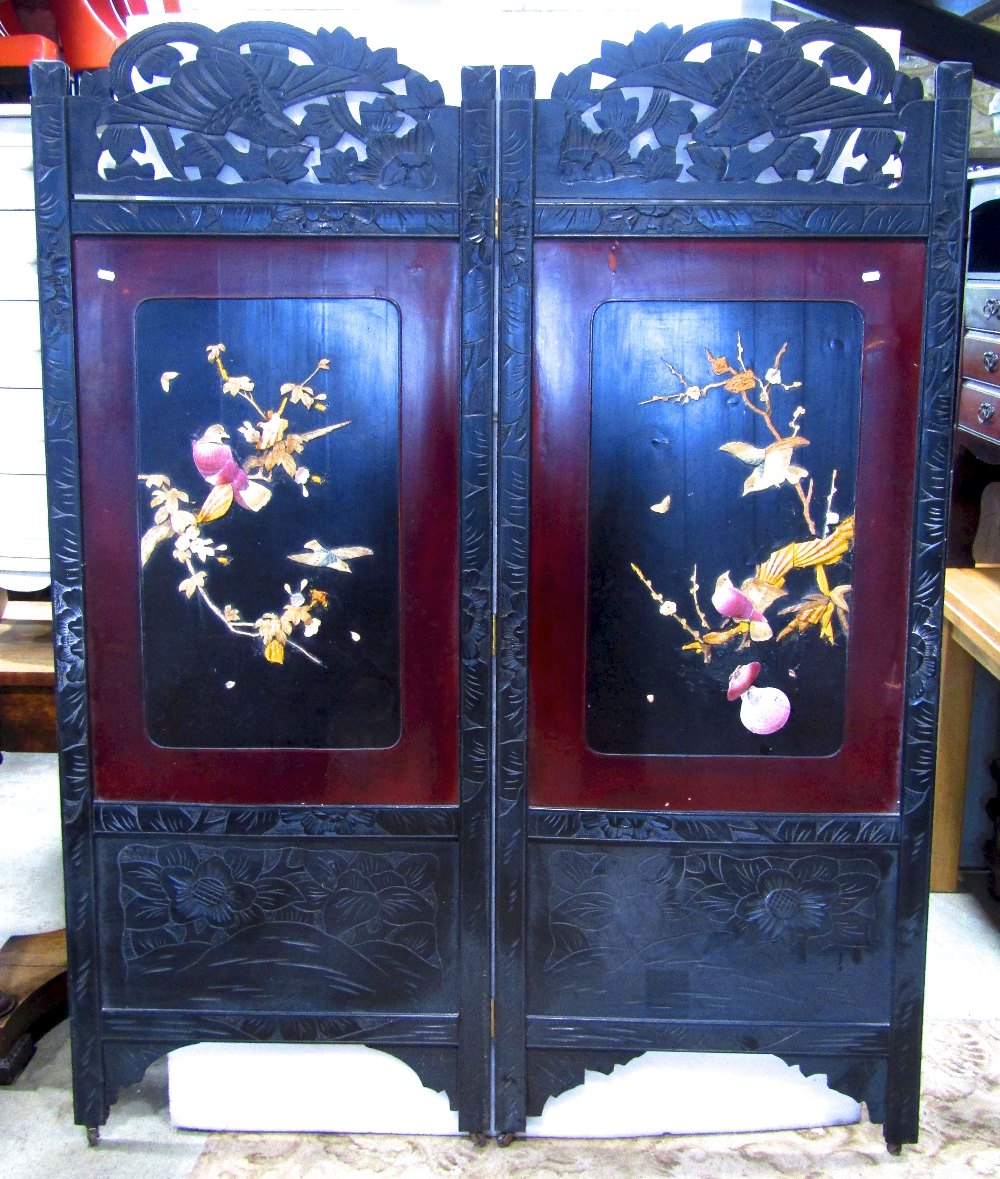 A Japanese freestanding two fold screen, the ebonised frame with carved foliate and bird detail