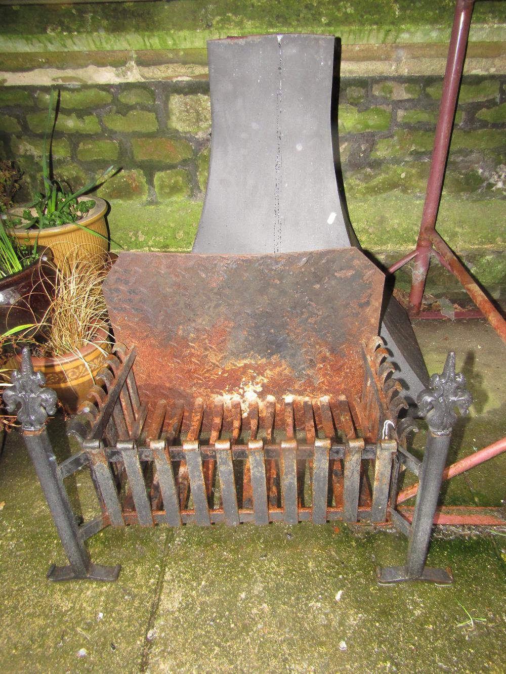 A cast iron fire basket of rectangular form and combined dogs, together with an associated chimney