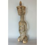 Tribal interest - a carved soft wood figure of a tribesman with a long neck and pointed hat, 62 cm