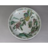 A 19th century oriental Famille Verte charger with painted decoration of male characters in a