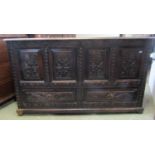 An antique oak mule chest with hinged lid over a panelled frame and two frieze drawers, the front