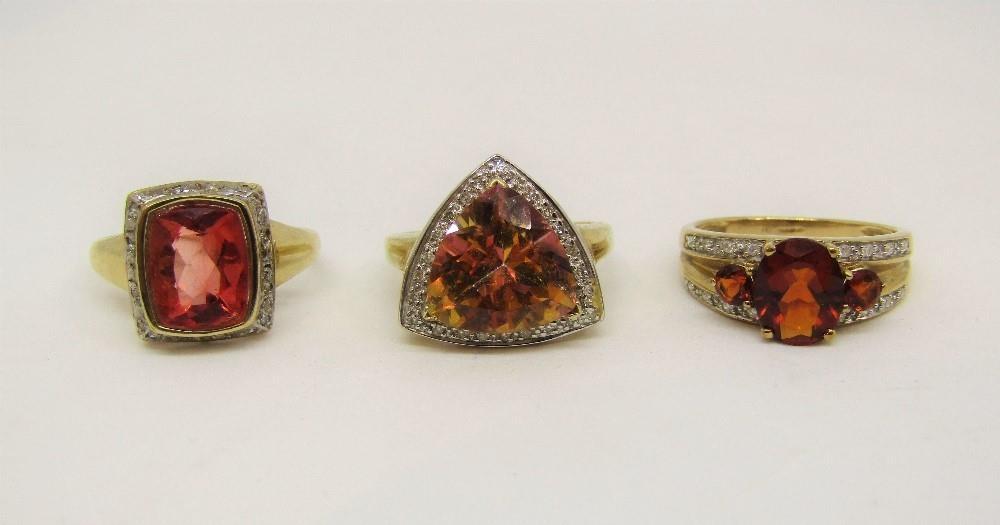 Three 9ct red gem stone dress rings set with diamonds; a flourite, quartz and topaz example, 11.6g
