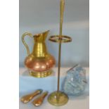 A large copper and brass ewer with loop handle, cylindrical stick stand, two powder flasks and a