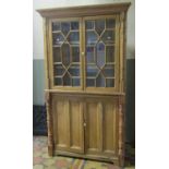 A 19th century Irish stripped pine freestanding corner cabinet enclosed by four doors, the upper