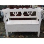 A small European pine bench/settle with hinged box seat, raised and shaped back with foliate