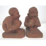 Pair of Stonehouse Brick and Tiles Works terracotta figures of seated imp type figures, 17cm high (